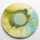A vinyl record with a marbled design of yellow, green, and blue swirls, centered on a plain background.