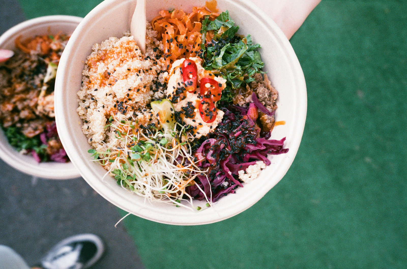 Overhead grain bowl with rice, greens, sprouts, and colorful toppings