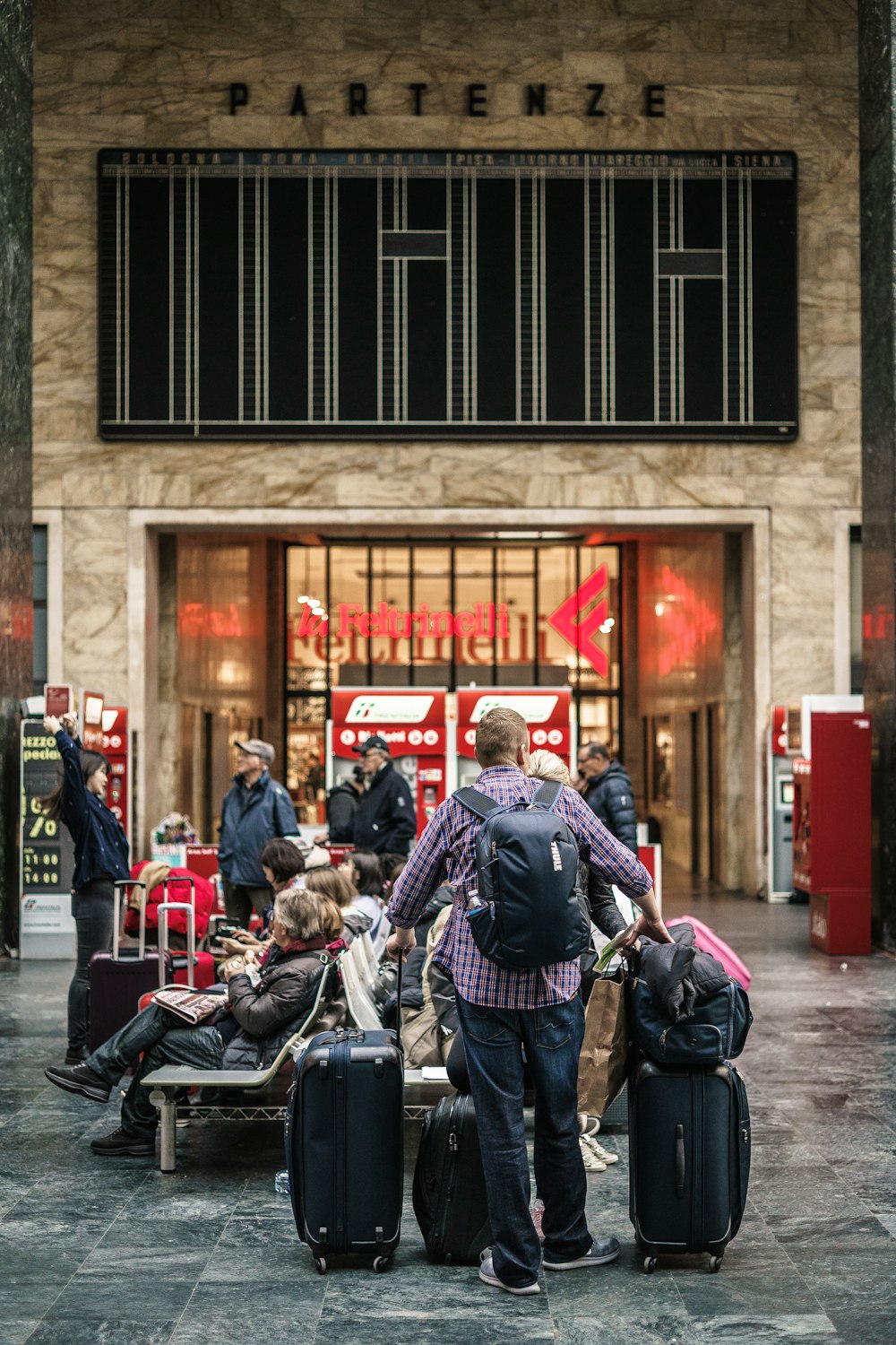 persona in piedi accanto alle borse dei bagagli