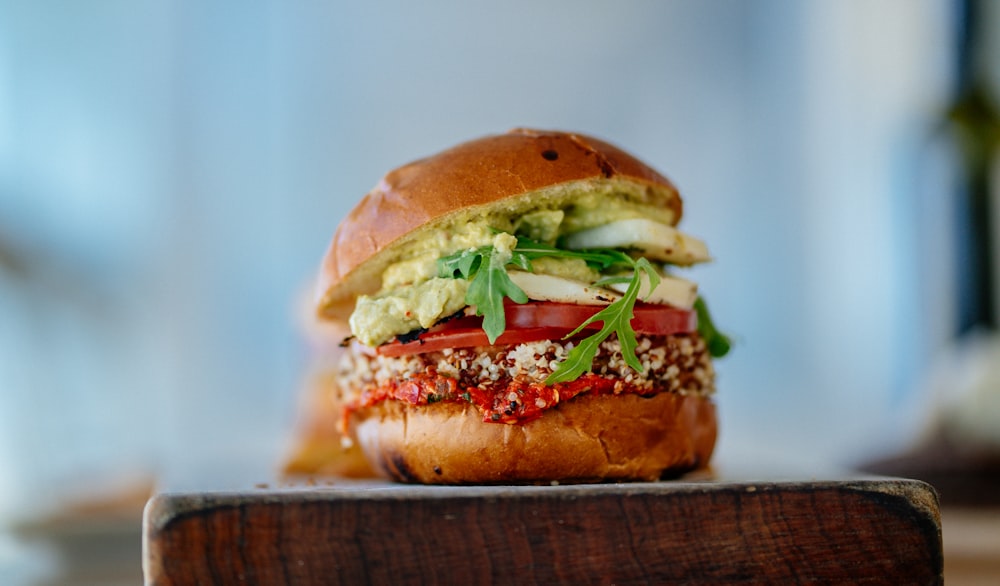 Selektive Fokusfotografie von Hamburgern mit geschnittenen Tomaten und Gemüse