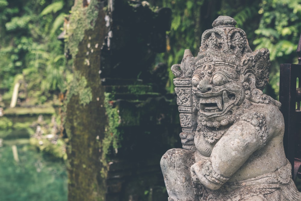 gray statuette near plants