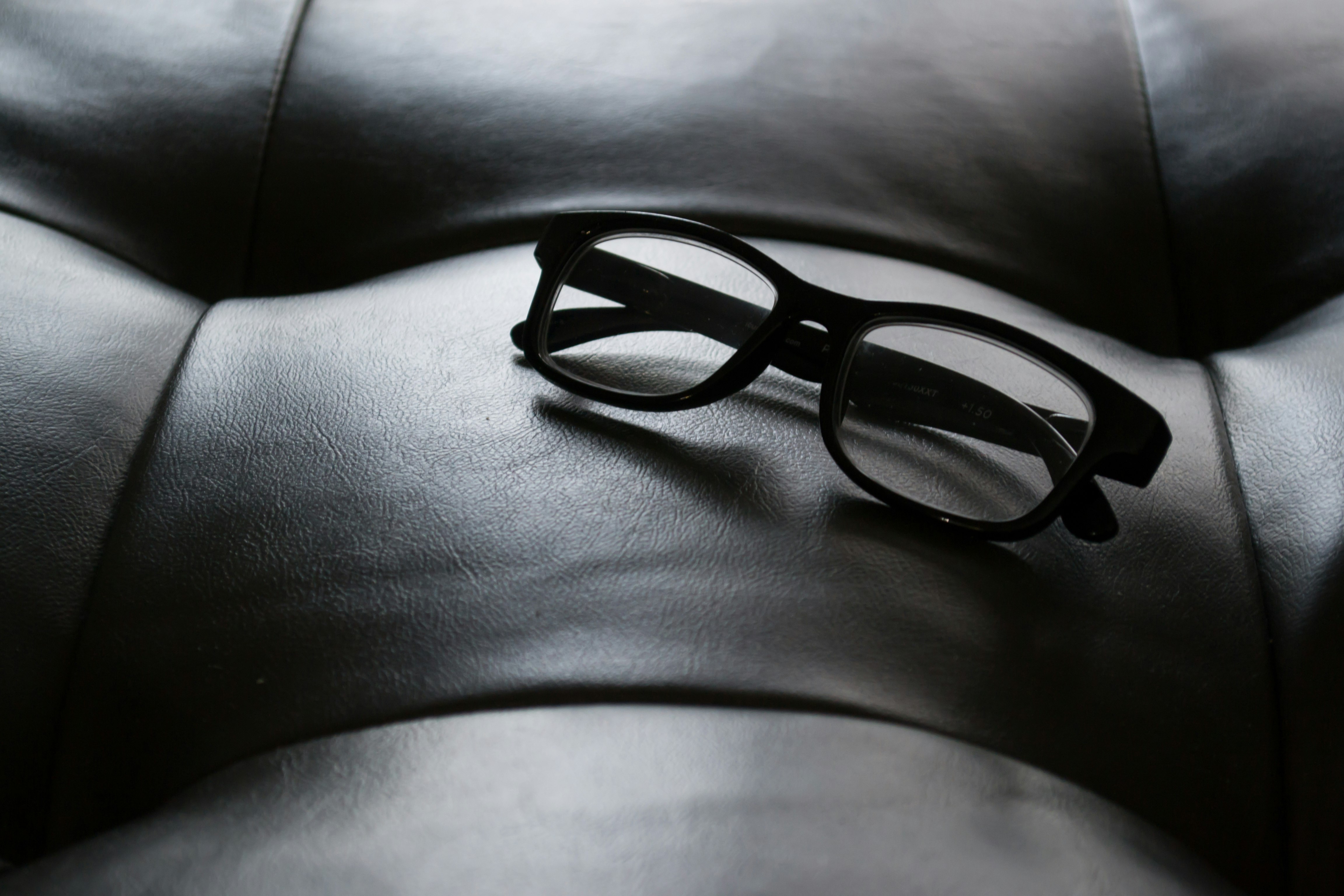 black framed eyeglasses on tufted leather