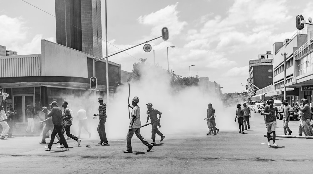 Graustufenfoto von Menschen auf der Straße in der Nähe von Gebäuden während des Tages