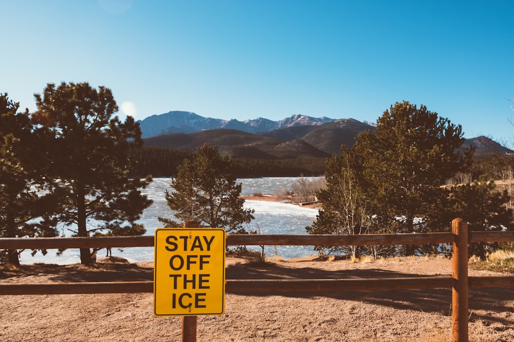 stay of the ice signage attached on fence near trees