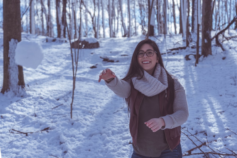 smiling woman wearing sweatshirt on snow covered ground