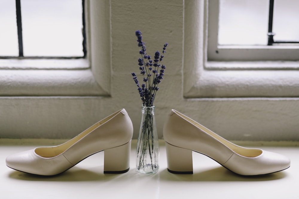 paid of beige shoes and lavender flowers