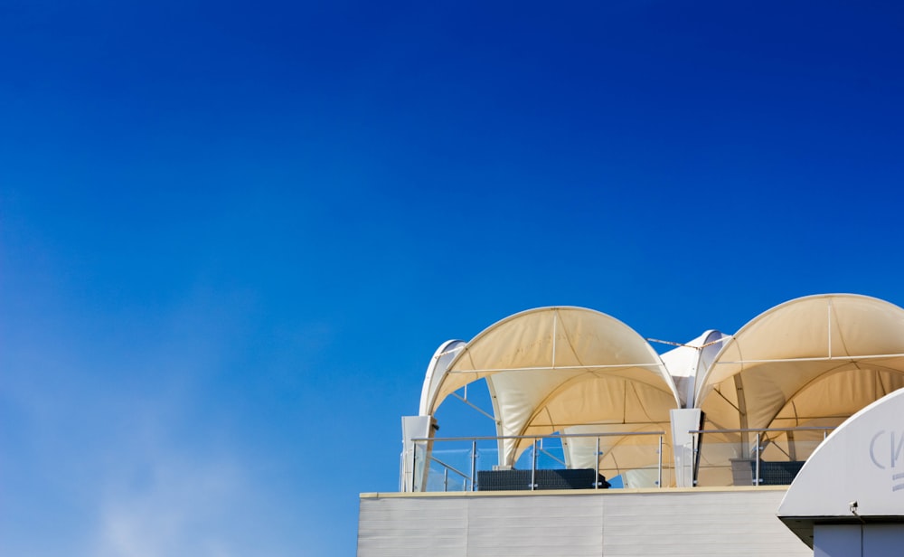 Deux tentes brunes au sommet d’un bâtiment sous un ciel bleu