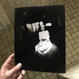 A close-up of a hand holding a faded photograph.