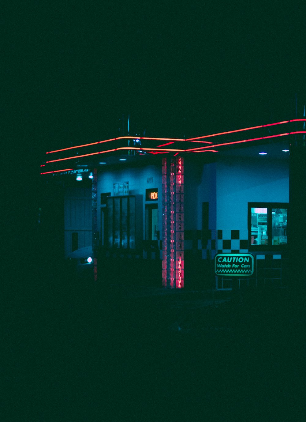 eine Tankstelle, die nachts mit Neonlichtern beleuchtet wird