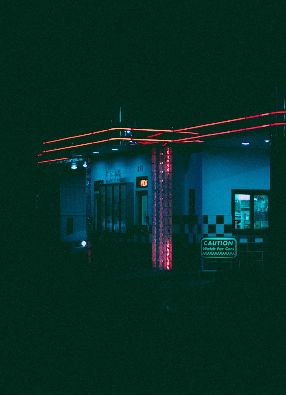 a gas station lit up at night with neon lights