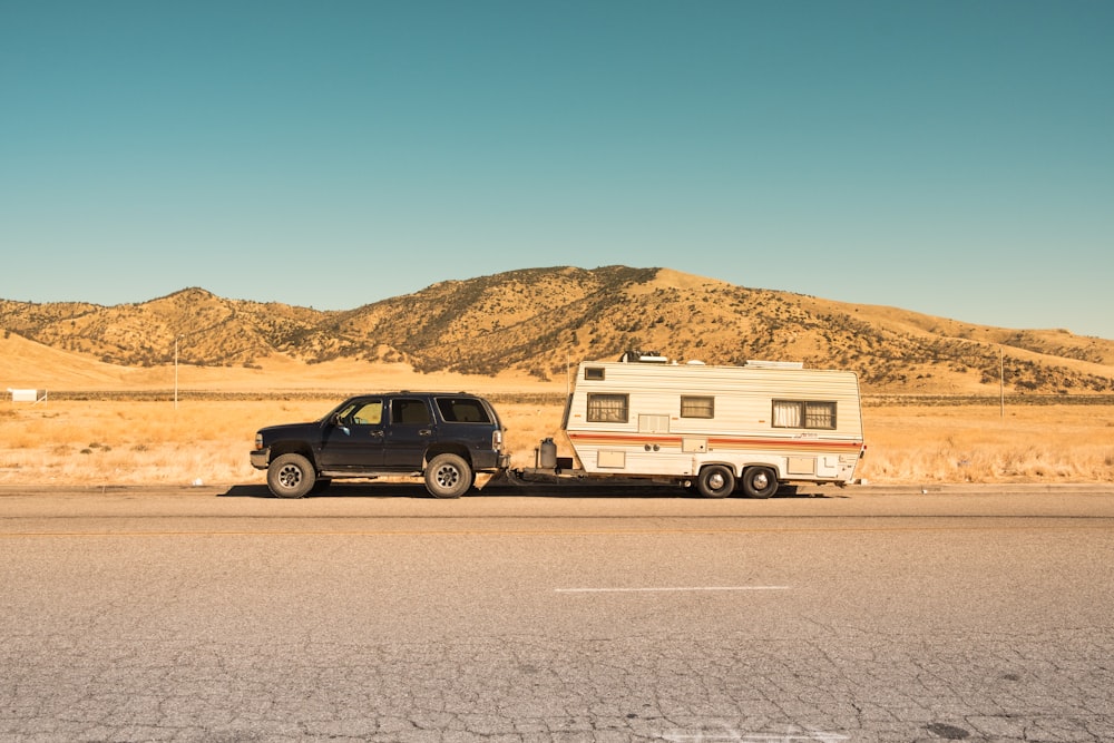 black SUV and white trailer