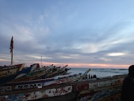 Sunset over the Senegal River with traditional pirogues floating gently.