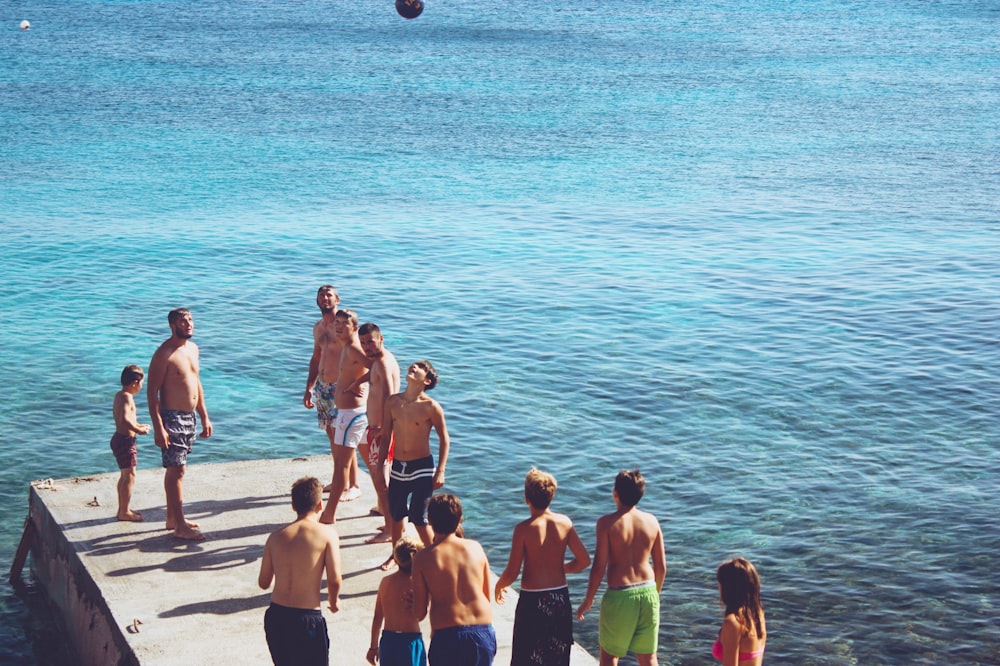 group of people playing ball on wooden dock