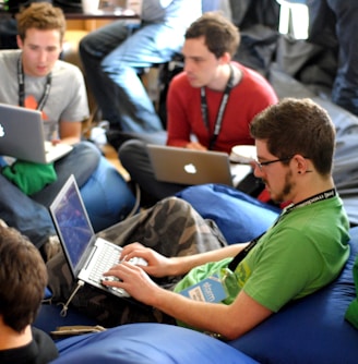 man sitting on blue bean bag usinglaptop