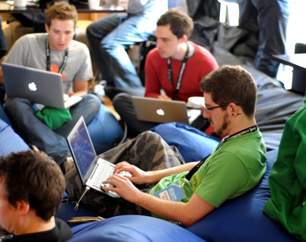 man sitting on blue bean bag usinglaptop