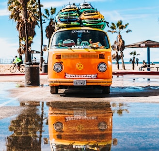 orange van with surfboard on top