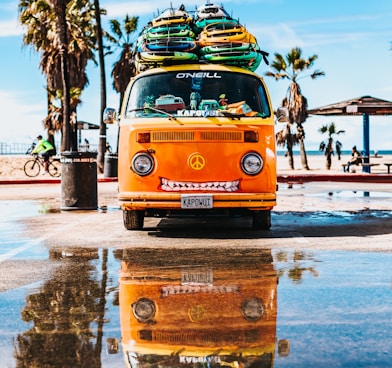 orange van with surfboard on top