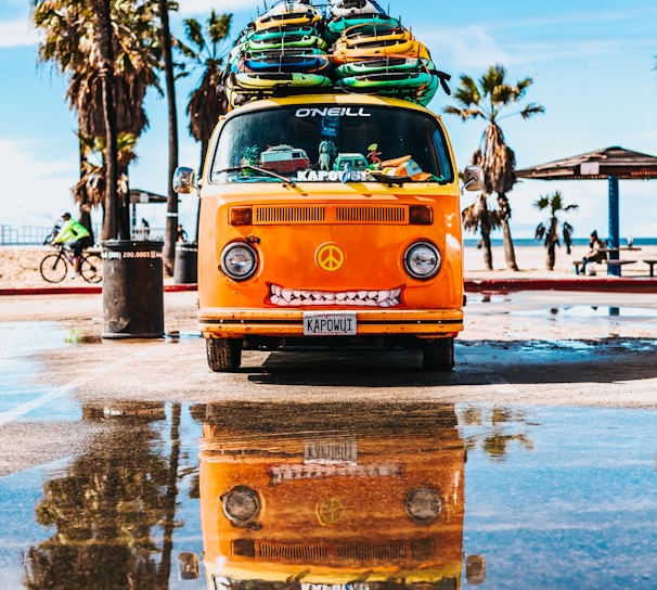 orange van with surfboard on top