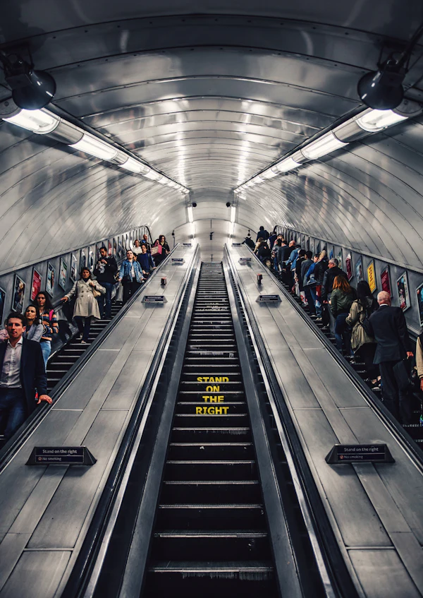 Commuters packed onto a crowded escalator in the London Underground at rush hour