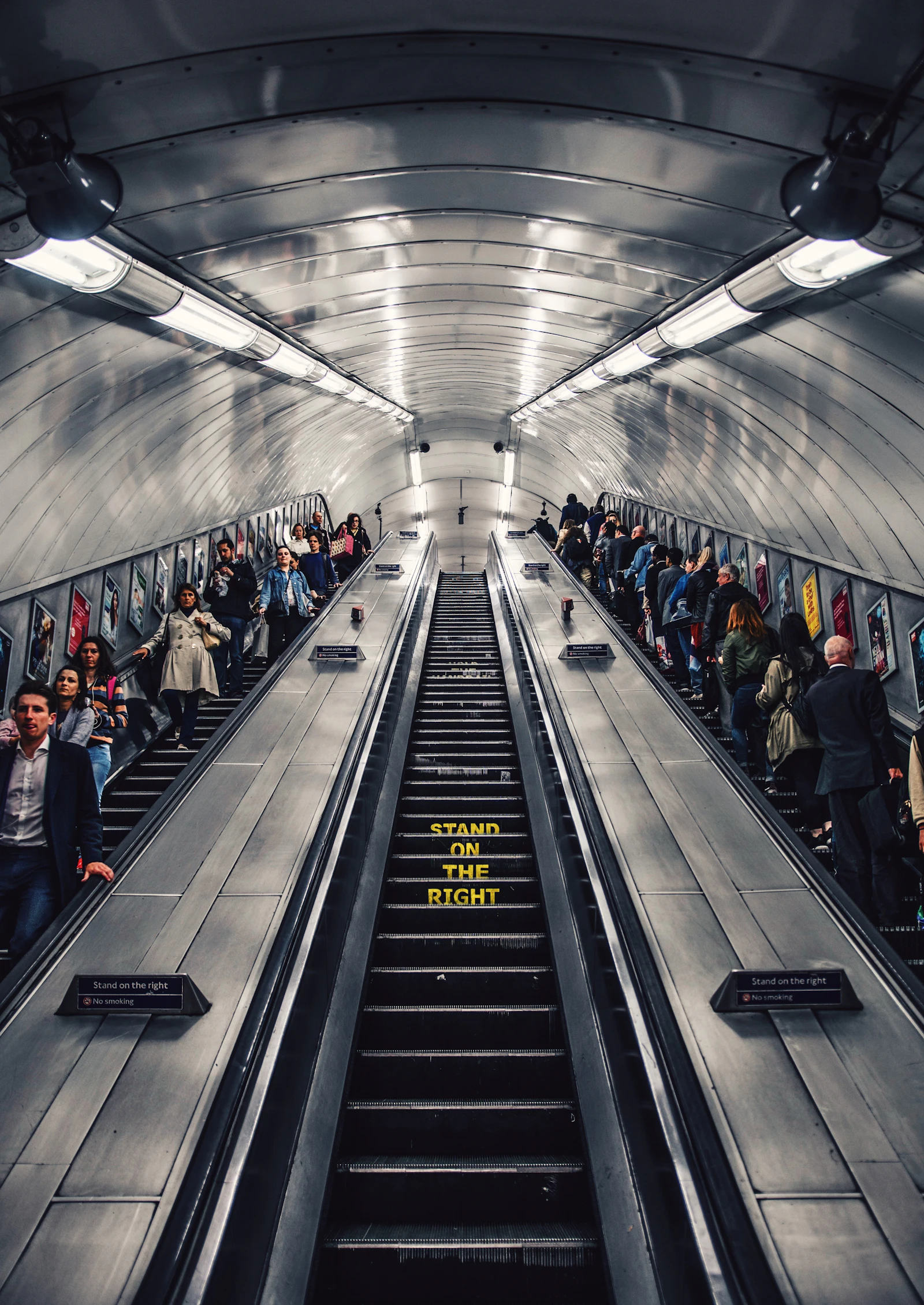 Commuters packed onto a crowded escalator in the London Underground at rush hour