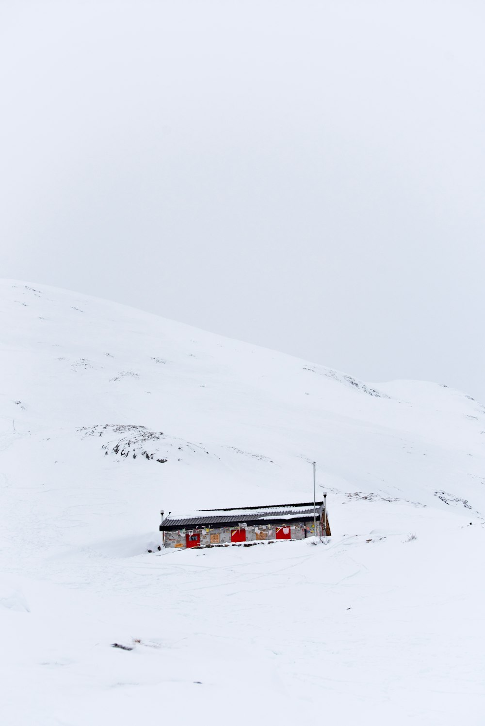 눈 산에 둘러싸인 회색 집