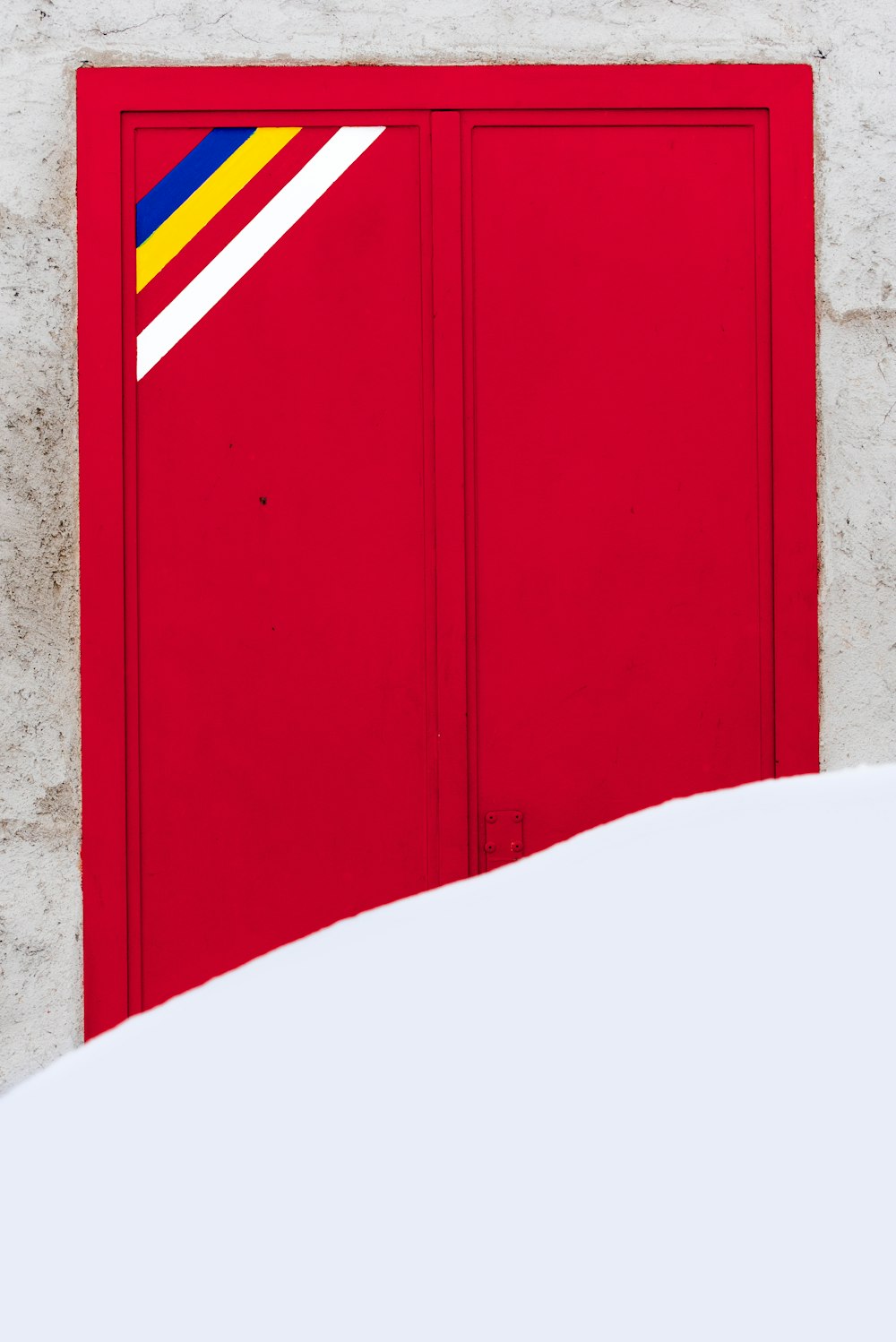 Porte en bois rouge sur mur en béton brun