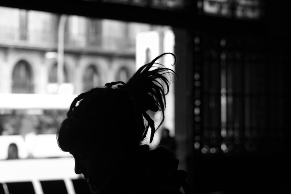 silhouette photography of woman near window