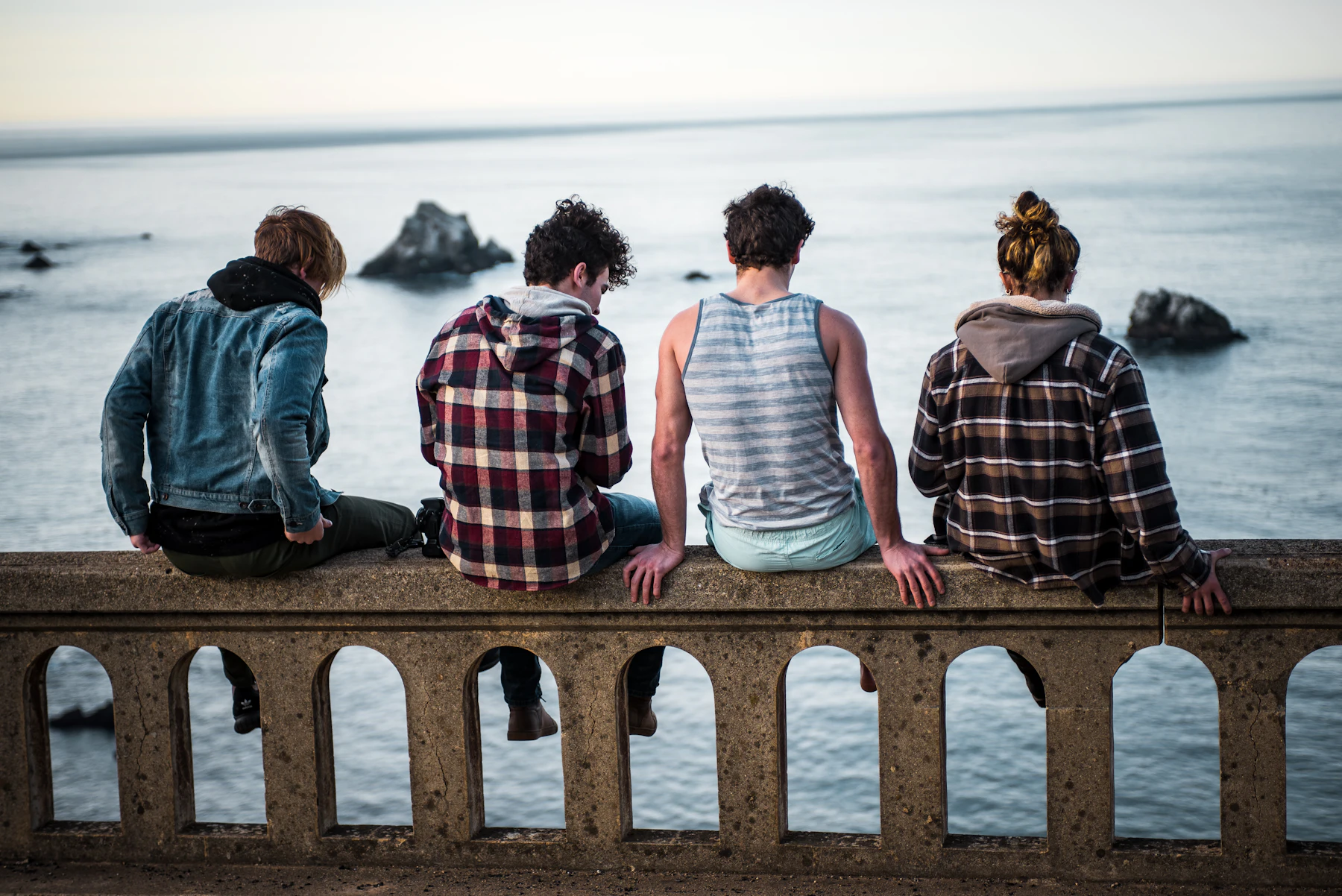Friends sitting on a bench by the water