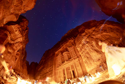 Historic masonry symbols carved on stone walls illuminated by candlelight.