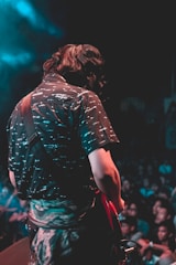 man playing red electric guitar during concert