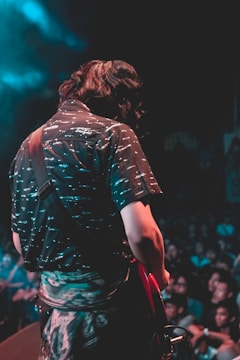 man playing red electric guitar during concert