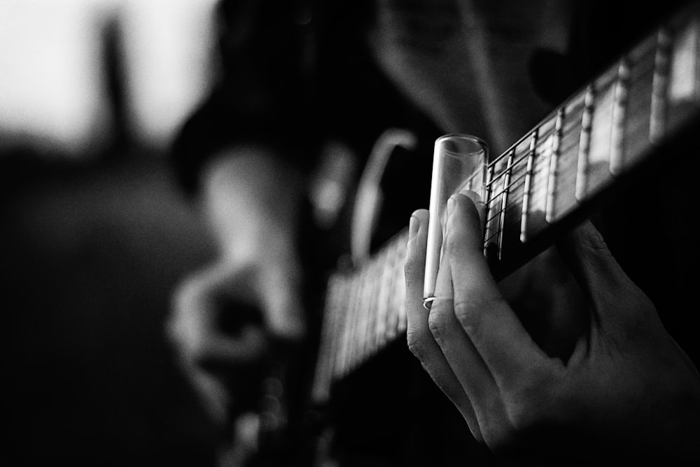 grayscale photography of person playing guitar