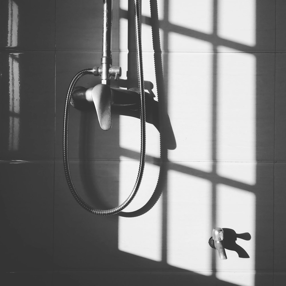 gray stainless steel shower head hanged on wall during daytime