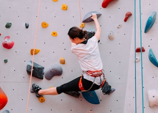 woman climbing on wall during daytime