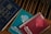 A group of religious books resting on a wooden surface. The blue book is a Holy Bible, while two spiral-bound books titled 'Scripture in Song' in teal and red are nearby, labeled as Book Two and Book One, respectively. The books have a vintage appearance.
