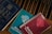 A group of religious books resting on a wooden surface. The blue book is a Holy Bible, while two spiral-bound books titled 'Scripture in Song' in teal and red are nearby, labeled as Book Two and Book One, respectively. The books have a vintage appearance.