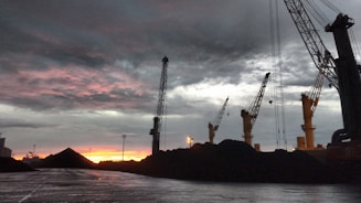 A coal mining site at sunrise with workers coordinating operations