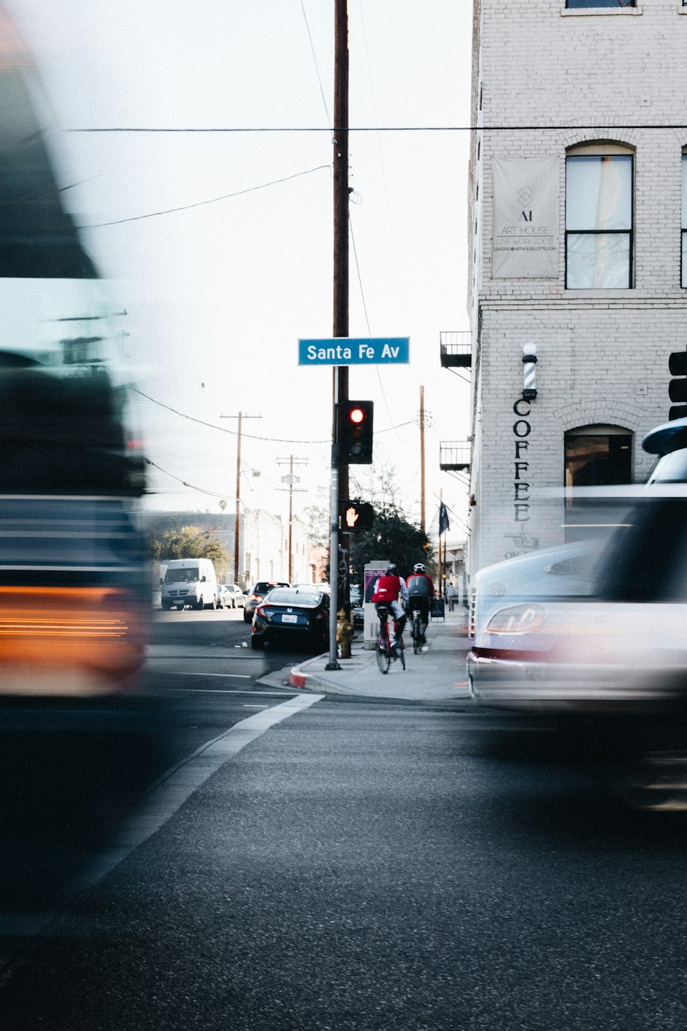 time-lapse photography of two cyclist beside gray post at daytime