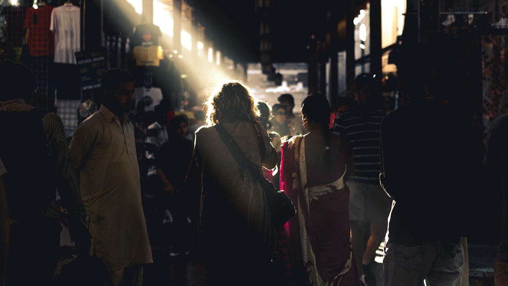 people waking between brown wooden stands during daytime