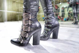 A pair of stylish black leather boots showcased with soft lighting.