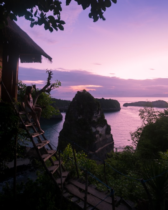 woman sitting on stair near mountains in Nusa Penida Indonesia