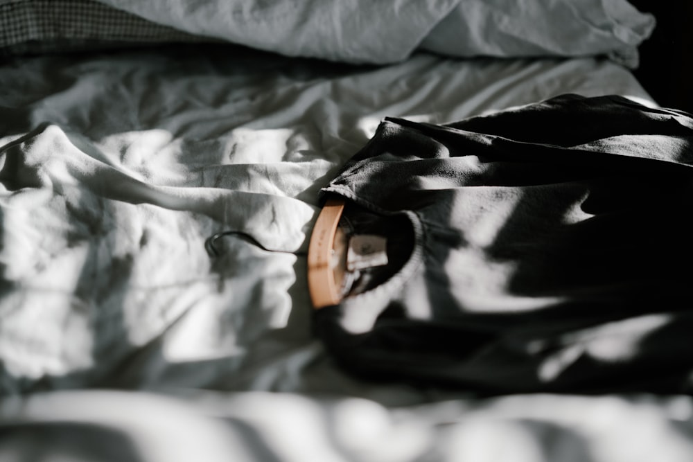 black long-sleeved shirt on bed sheet