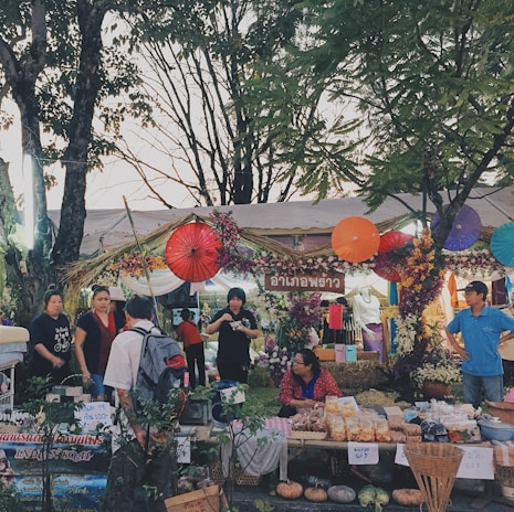 A vibrant local marketplace with diverse small business stalls and happy customers interacting.