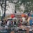 A vibrant market scene filled with colorful stalls and enthusiastic locals engaging with tourists.
