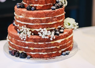 icing-covered cake beside cupcakes