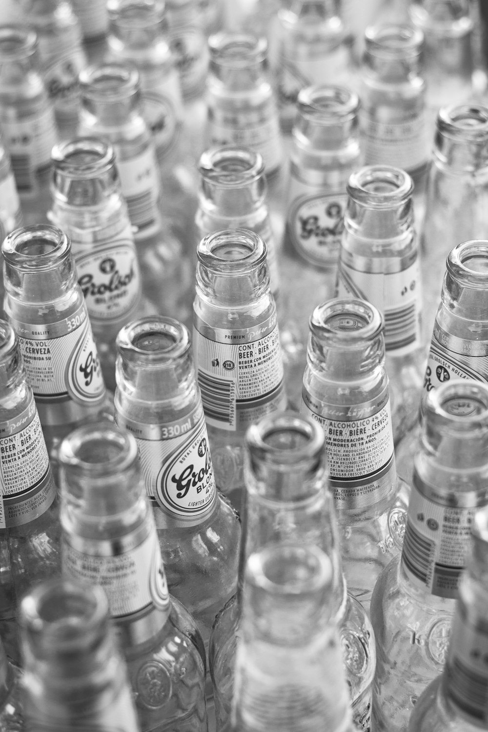 grayscale photo of glass bottles