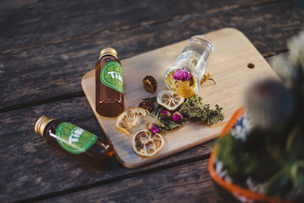 sliced lemon on chopping board along with brown glass bottles