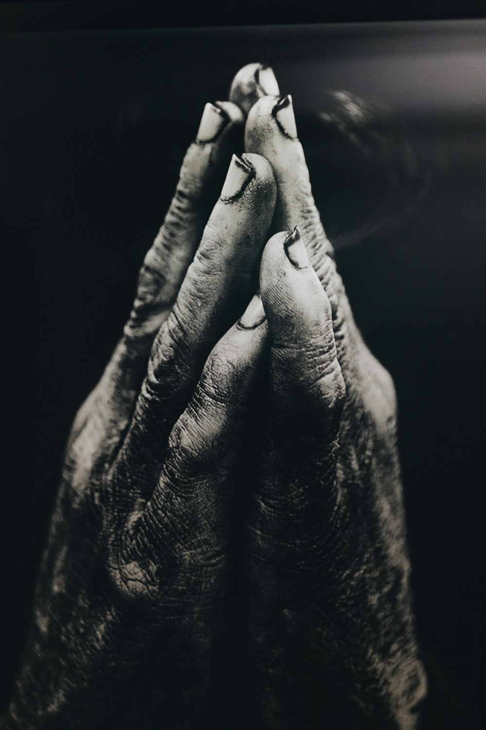 fotografia em tons de cinza de mãos orantes