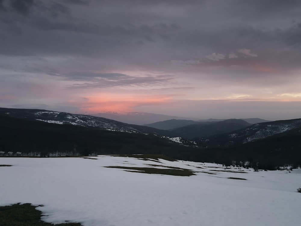 mountains under gray sky at golden hour