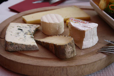 Close-up of a hand selecting a wedge of cheese from a beautifully arranged cheese platter.